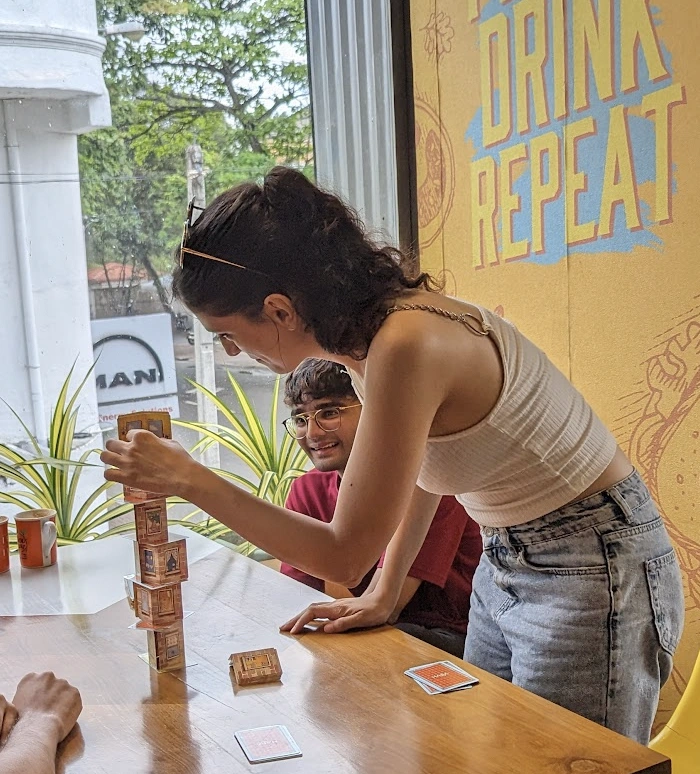 A girl plays a game called rhino hero which is similar to jenga