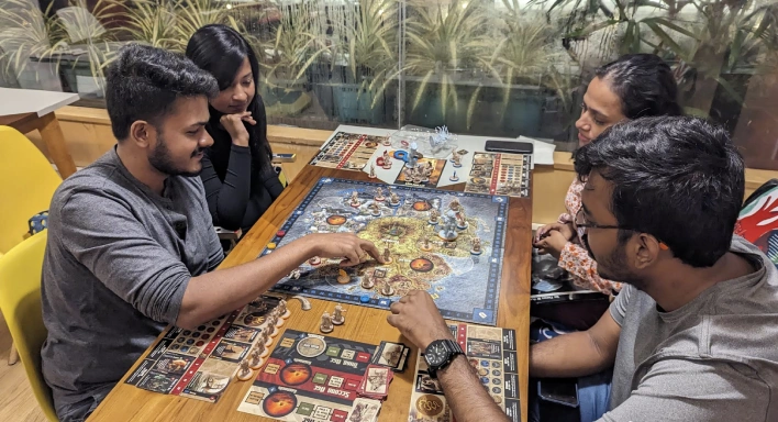 A set of four players playing a board game